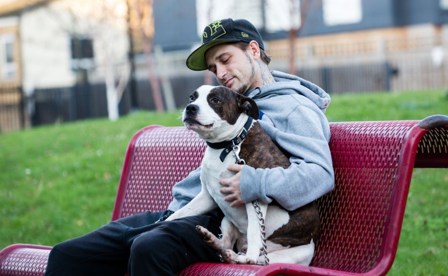 A man sitting on a bench with his dog